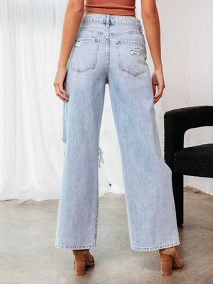 Distressed light wash wide leg denim jeans with a flare, showing ripped details.