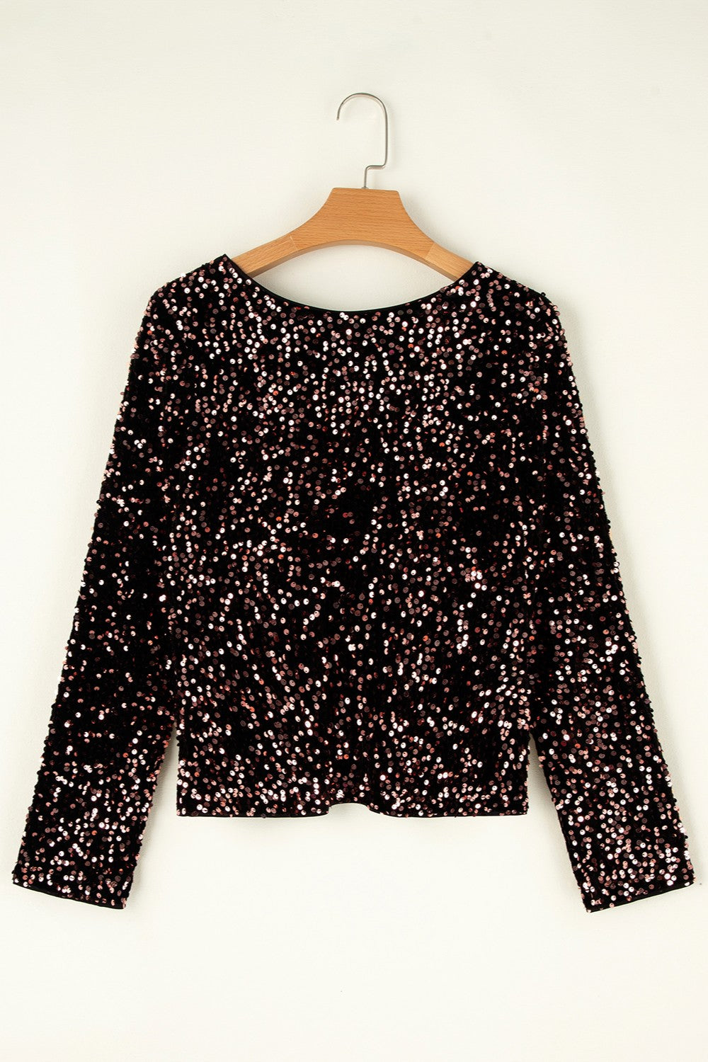Black sequin backless blouse with long sleeves and a round neckline.