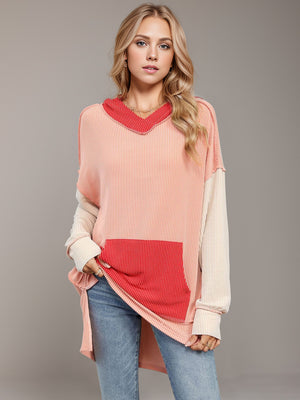 Waffle knit tunic with contrast colorblock design, V-neck hood, and front pocket.