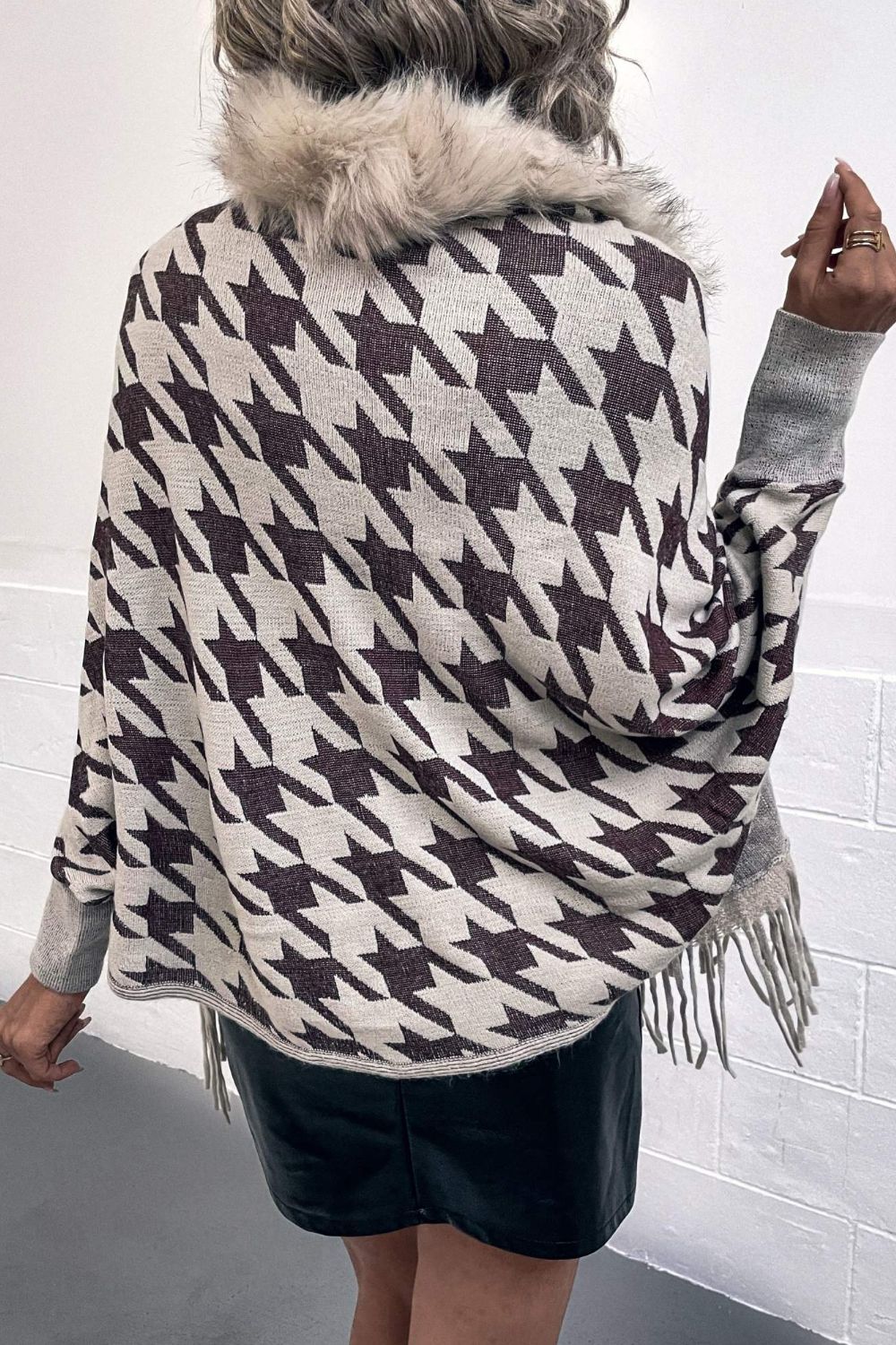 Houndstooth faux fur collar poncho with fringe hem and grey sleeves.