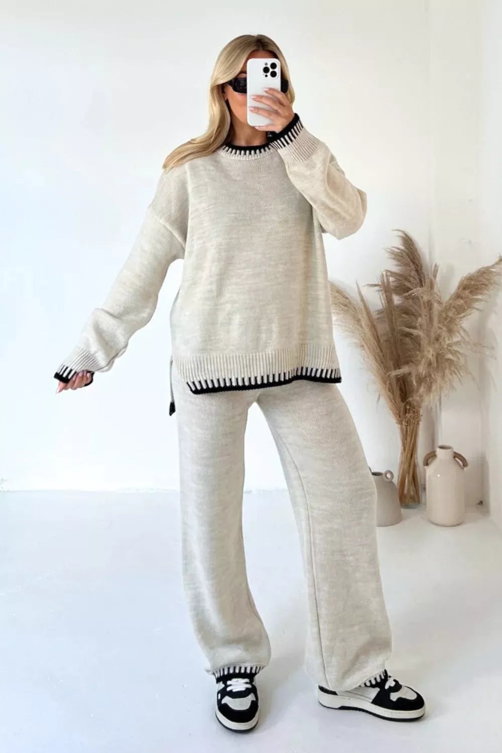 Beige relaxed fit sweater set with contrast black trim on neckline, cuffs, and hem.