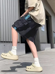 Black denim cargo shorts with blue braided drawstring detail and utility pockets.