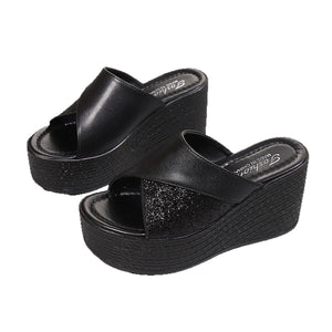 Black open-toe wedge sandals with glitter-embellished cross-over straps.
