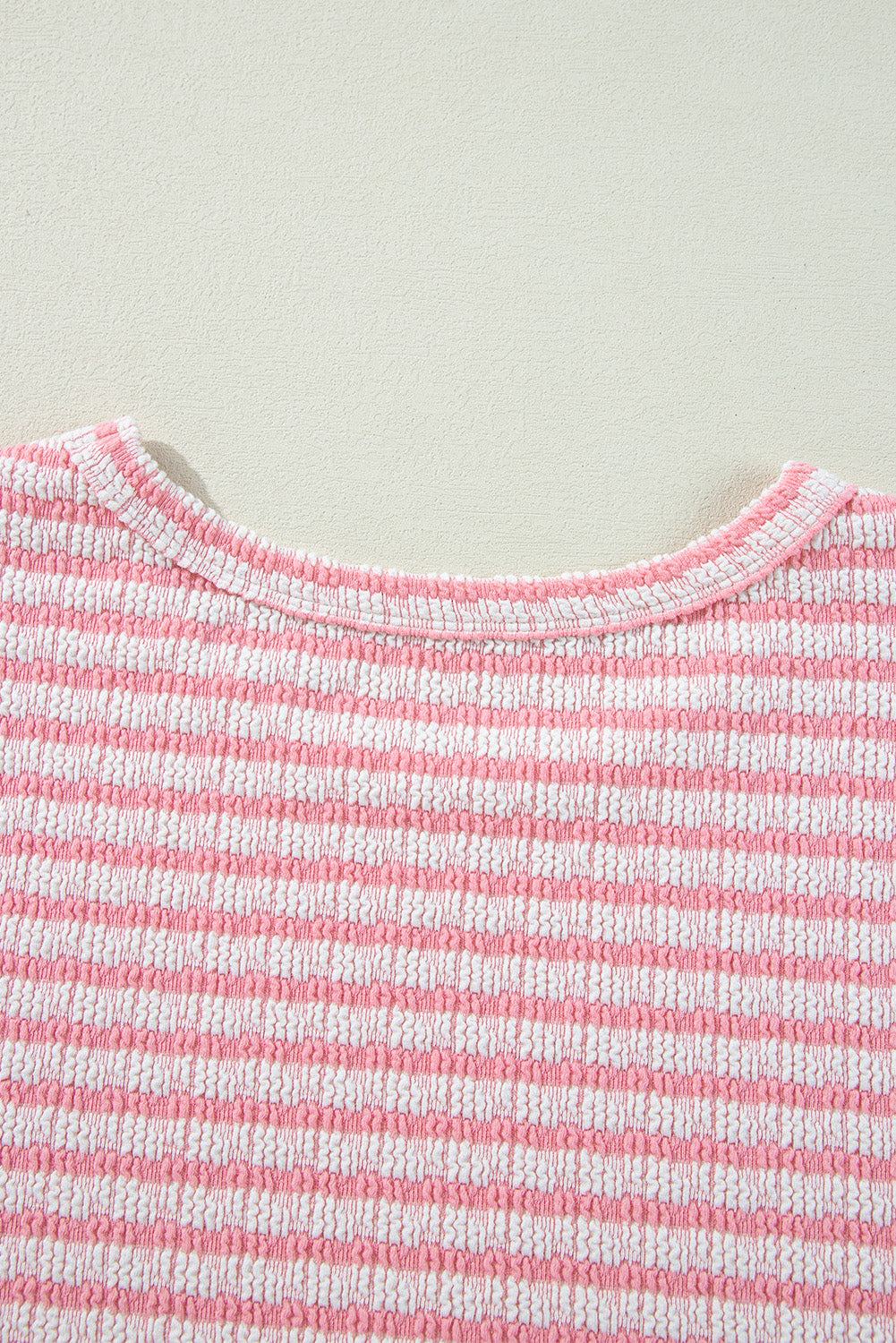 Textured stripe puff sleeve top in blush pink with a round neckline.