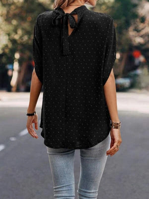 Black textured dot back-tie blouse with short sleeves and a V-neck detail.