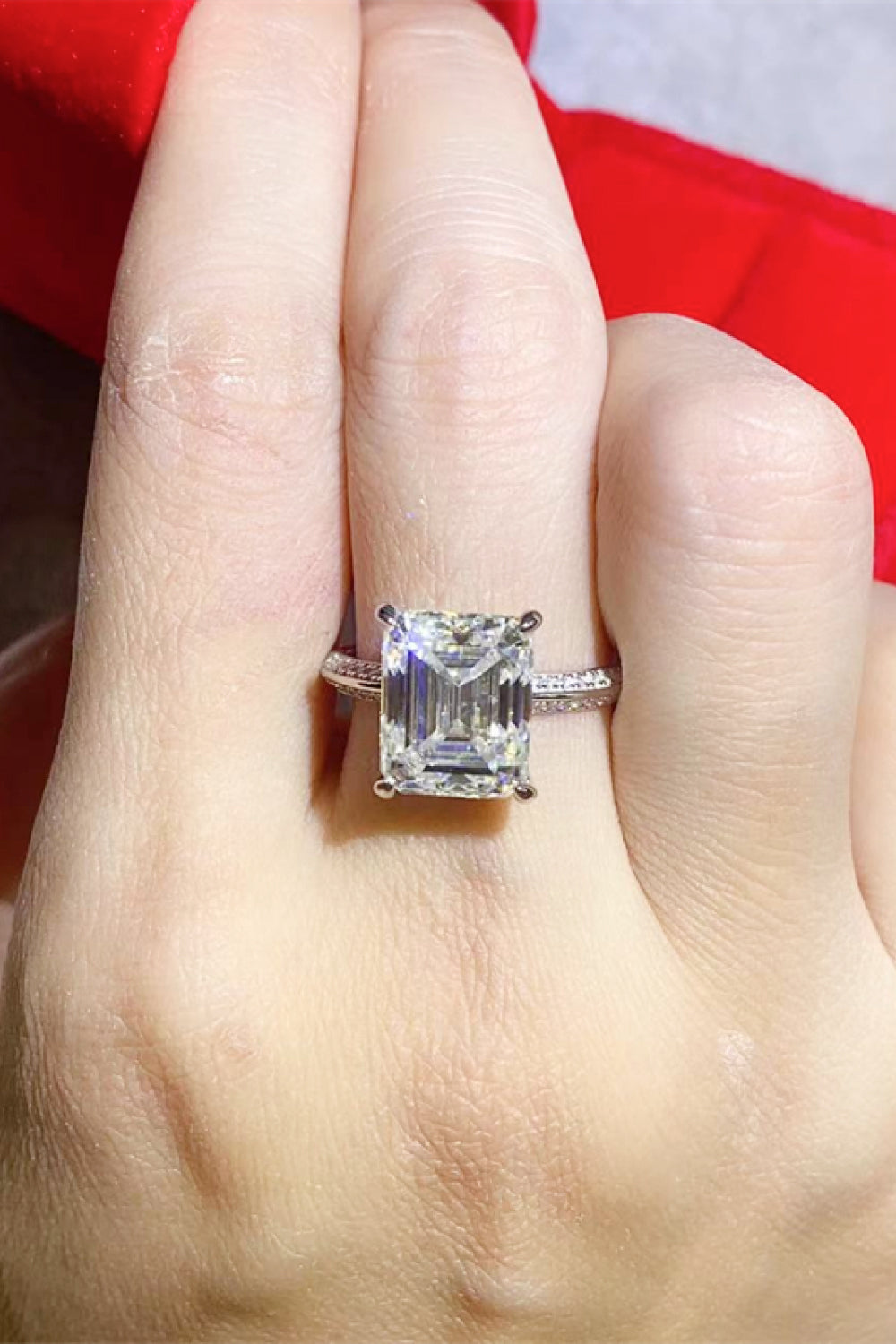 Platinum ring with emerald cut solitaire diamond and pavé band.