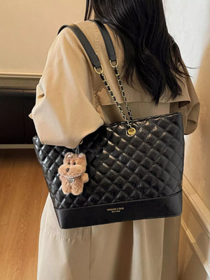 Black quilted shoulder bag with chain straps and teddy bear charm