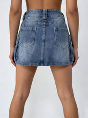 Plus size washed denim cargo skirt in dark blue with button closure and utility pockets.
