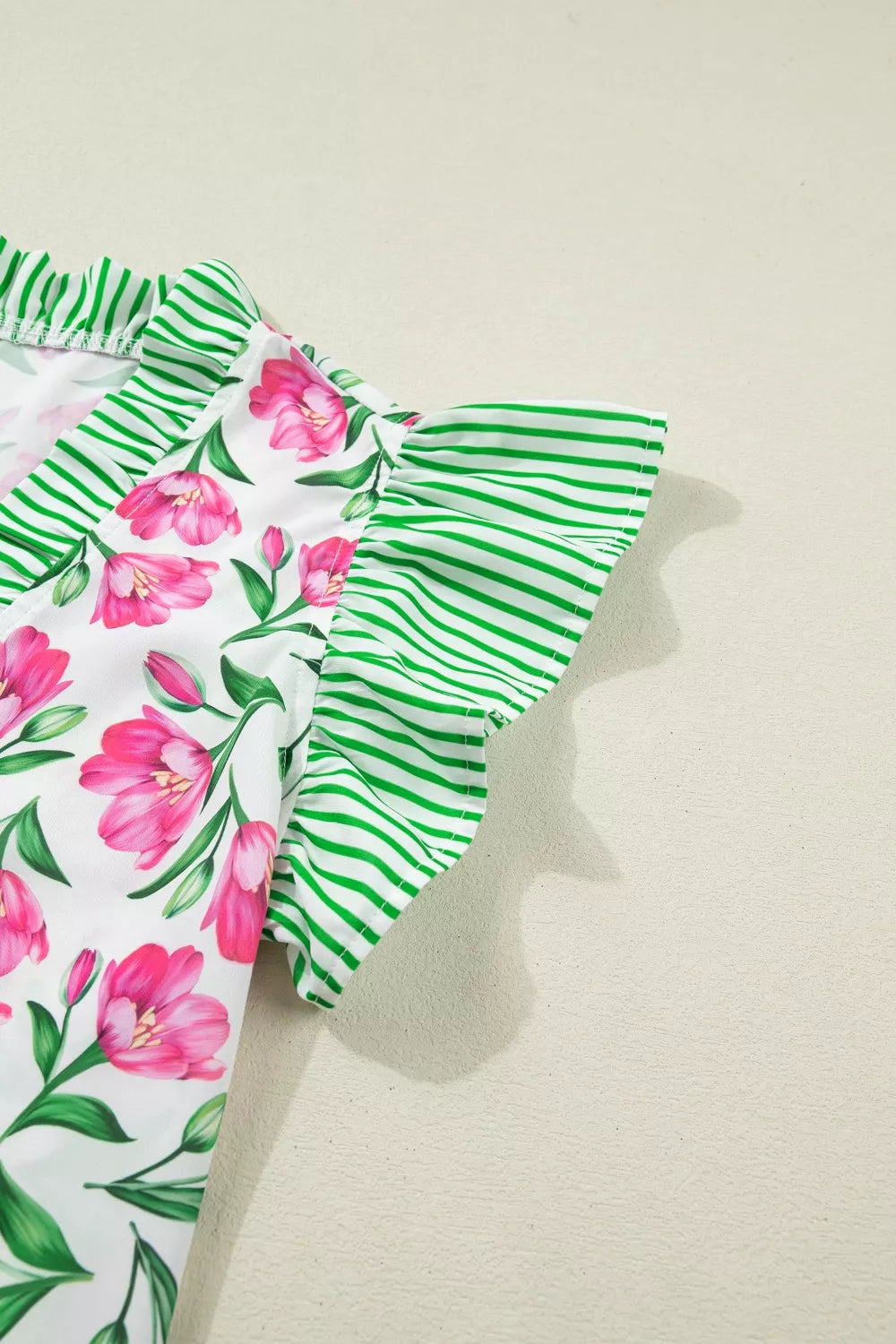 Tulip print V-neck polyester blouse with ruffled green striped sleeves and neckline.