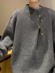 Gray knit sweater with mock neck and gold button detail on the side.