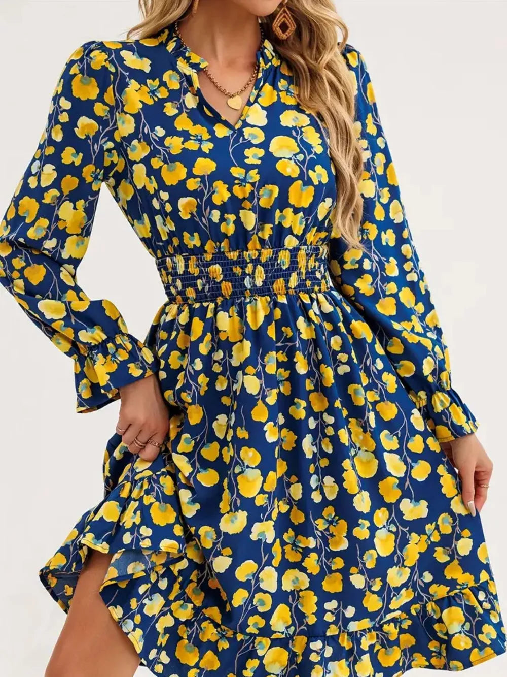 Blue floral smocked dress with v-neck and ruffled hem.
