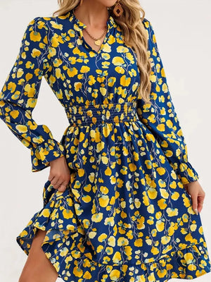 Blue floral smocked dress with v-neck and ruffled hem.