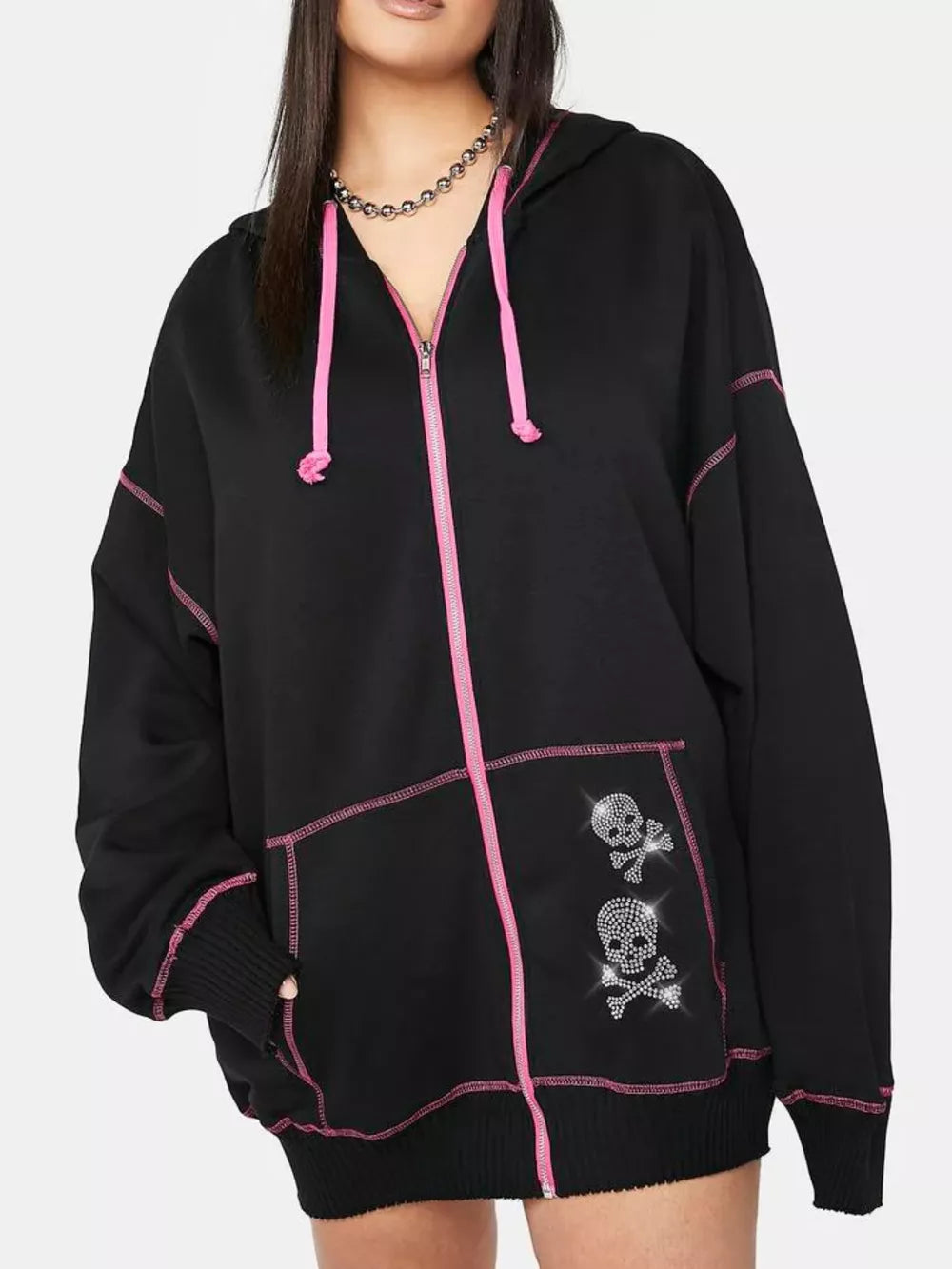 Black zip-up hoodie with pink contrast stitching, drawstring hood, and rhinestone skull graphics.
