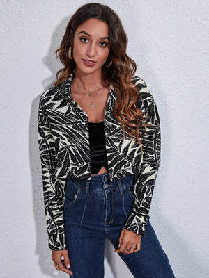 Checkerboard cropped shirt jacket in black with a leaf pattern, buttoned front, and collar.