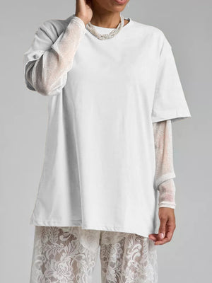 White oversized t-shirt with sheer, sparkly long sleeves layered underneath.