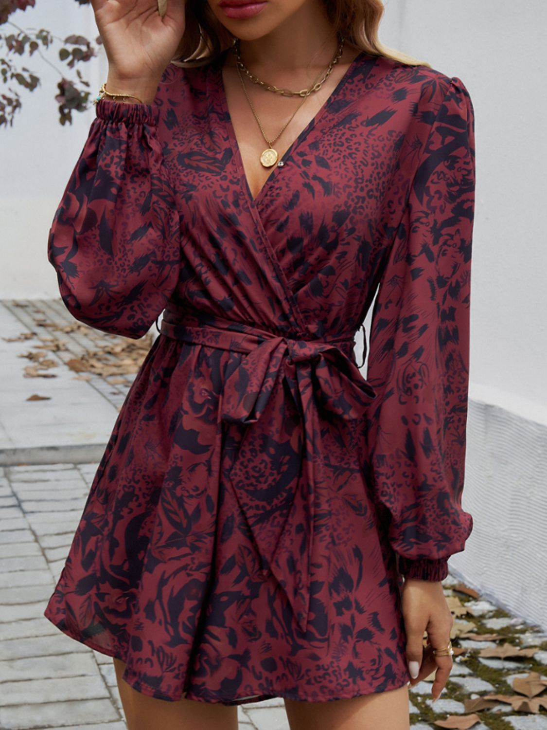 Floral wrap romper in dark brown with blouson sleeves and tie waist