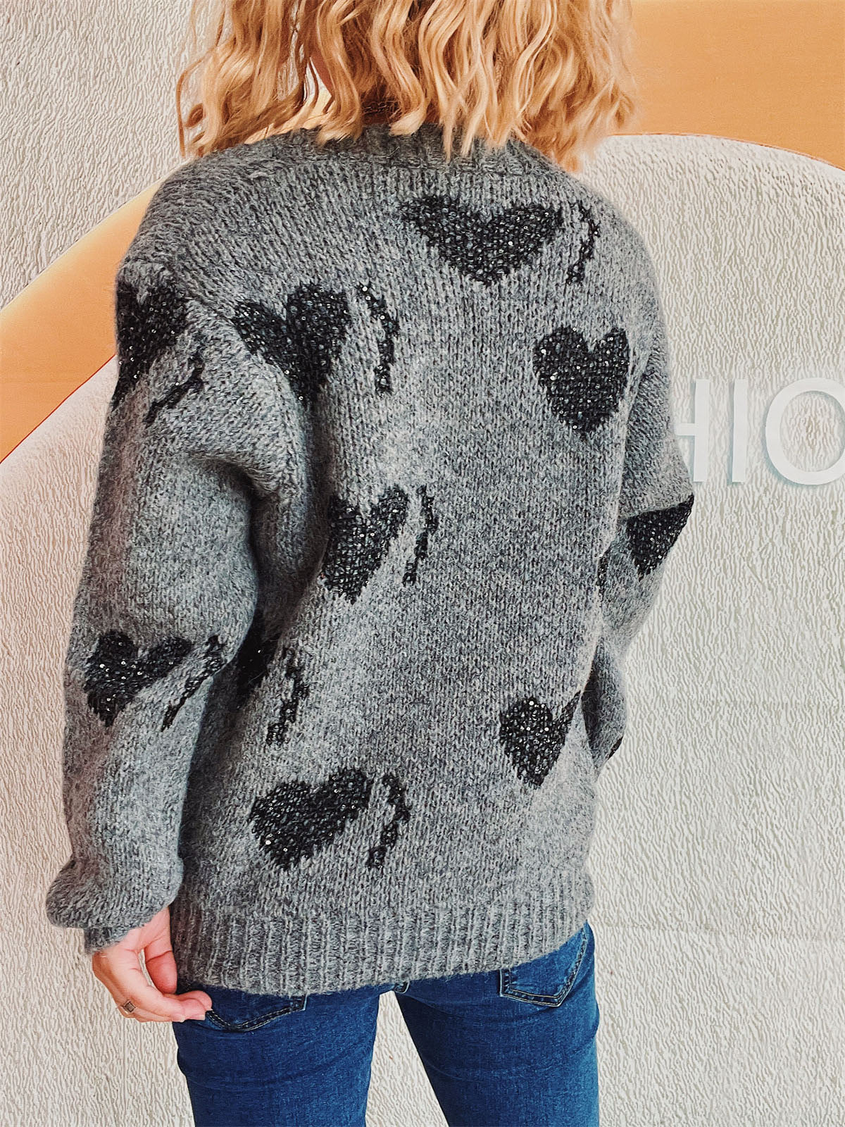 Dark gray acrylic knit cardigan with black sequin heart motif and button front.