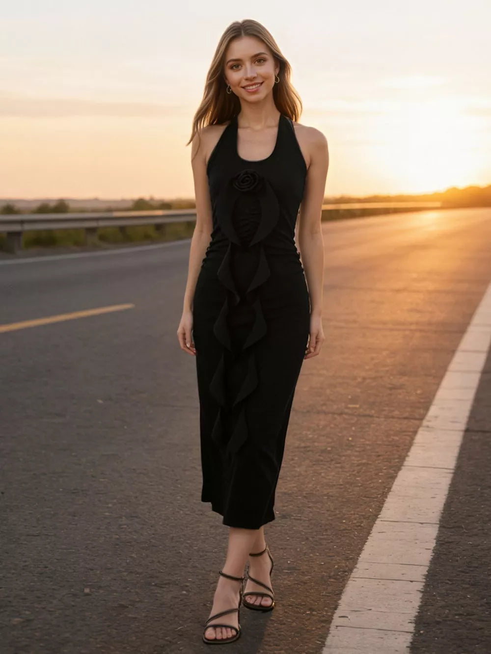 Black halter midi dress with ruffle detail and rose accent, styled with strappy heels.