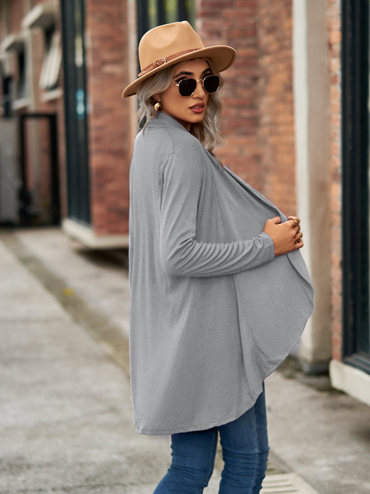 Draped cascade cardigan in heather grey with long sleeves and an open front, styled with a hat and sunglasses.