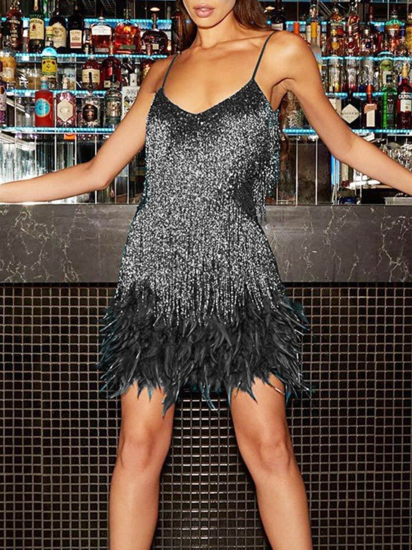 Black sequin fringe mini dress with feather trim and spaghetti straps.