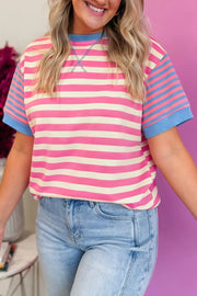 Short sleeve t-shirt with pink and cream horizontal stripes, blue striped sleeves, and contrast stitching.
