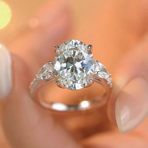 Dazzling Moissanite oval ring in sterling silver with side pear stones and pave band.