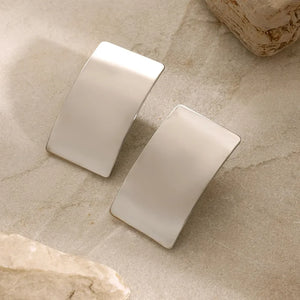 Sculpted silver-tone statement earrings with a polished finish.