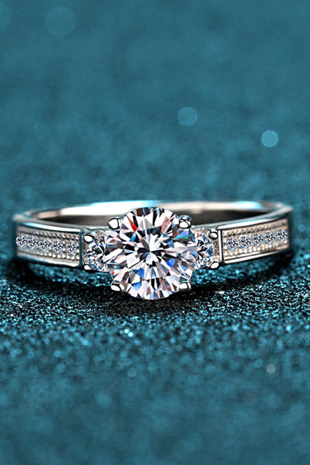 Silver rhodium engagement ring with pavé band and solitaire center stone.