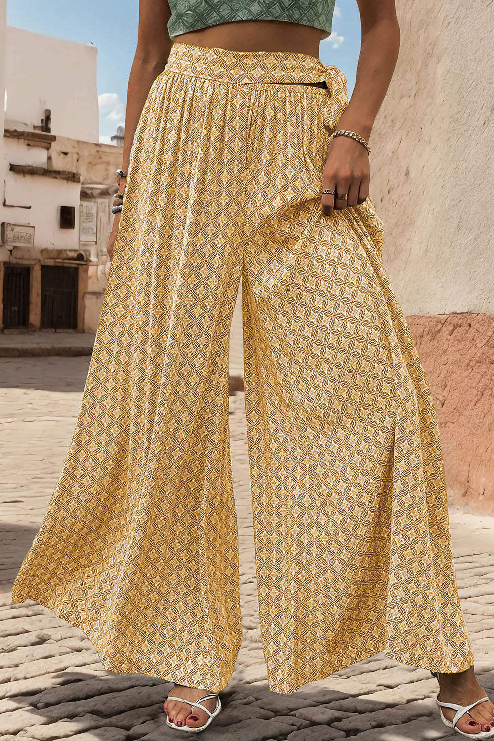 Yellow geometric print wide-leg palazzo trousers with a tie waist and side slits.