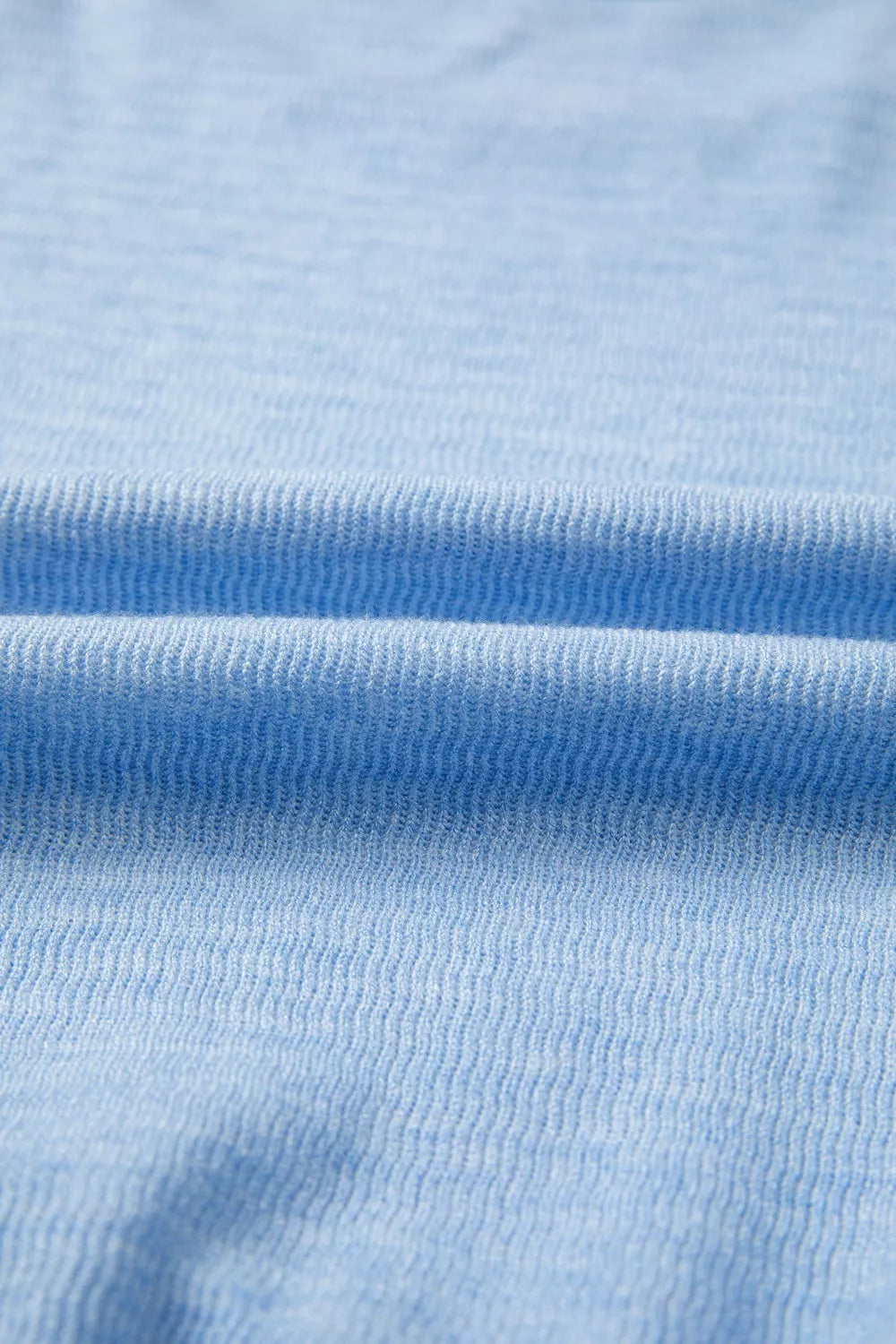Light blue knit fabric detail with ribbed texture.