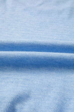 Light blue knit fabric detail with ribbed texture.