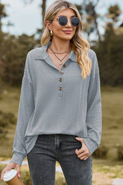 Light blue textured polo-neck sweater with button detail and long sleeves.