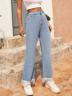 Light wash denim flare jeans with a fringed hem.