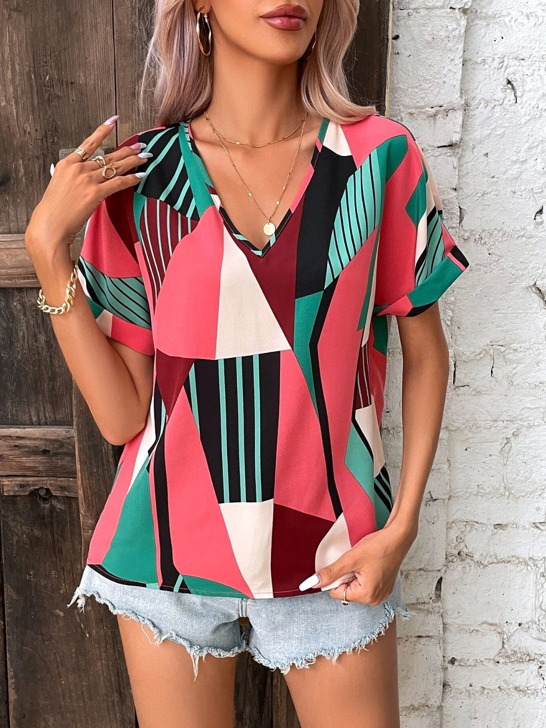 Geometric print V-neck blouse with short sleeves in multicolor.