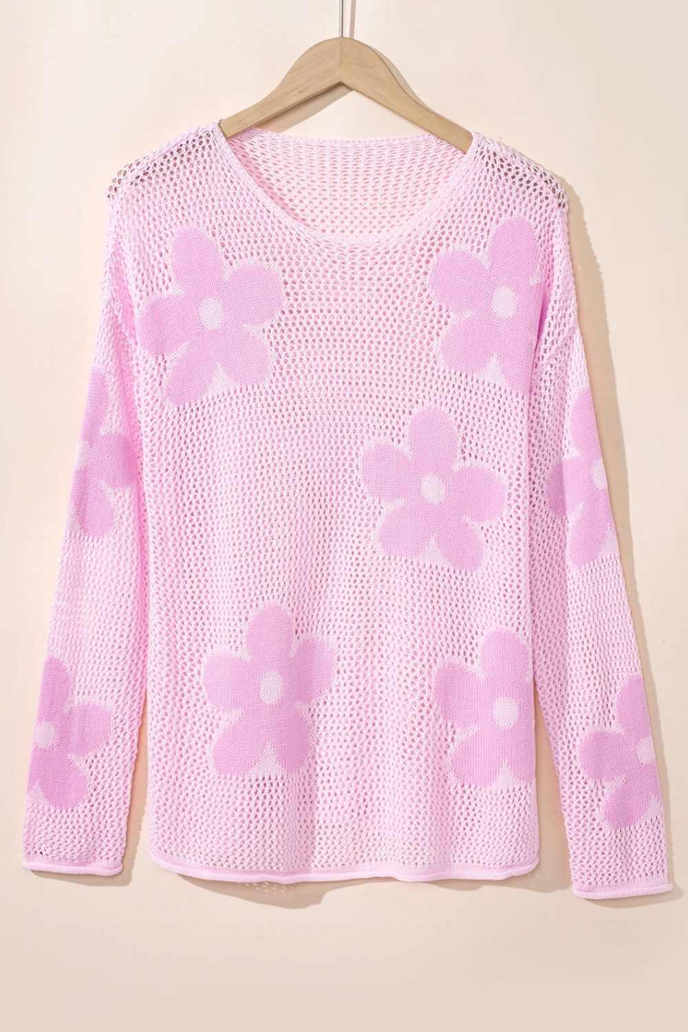 Openwork floral intarsia sweater in blush pink acrylic with a v-neck and long sleeves.