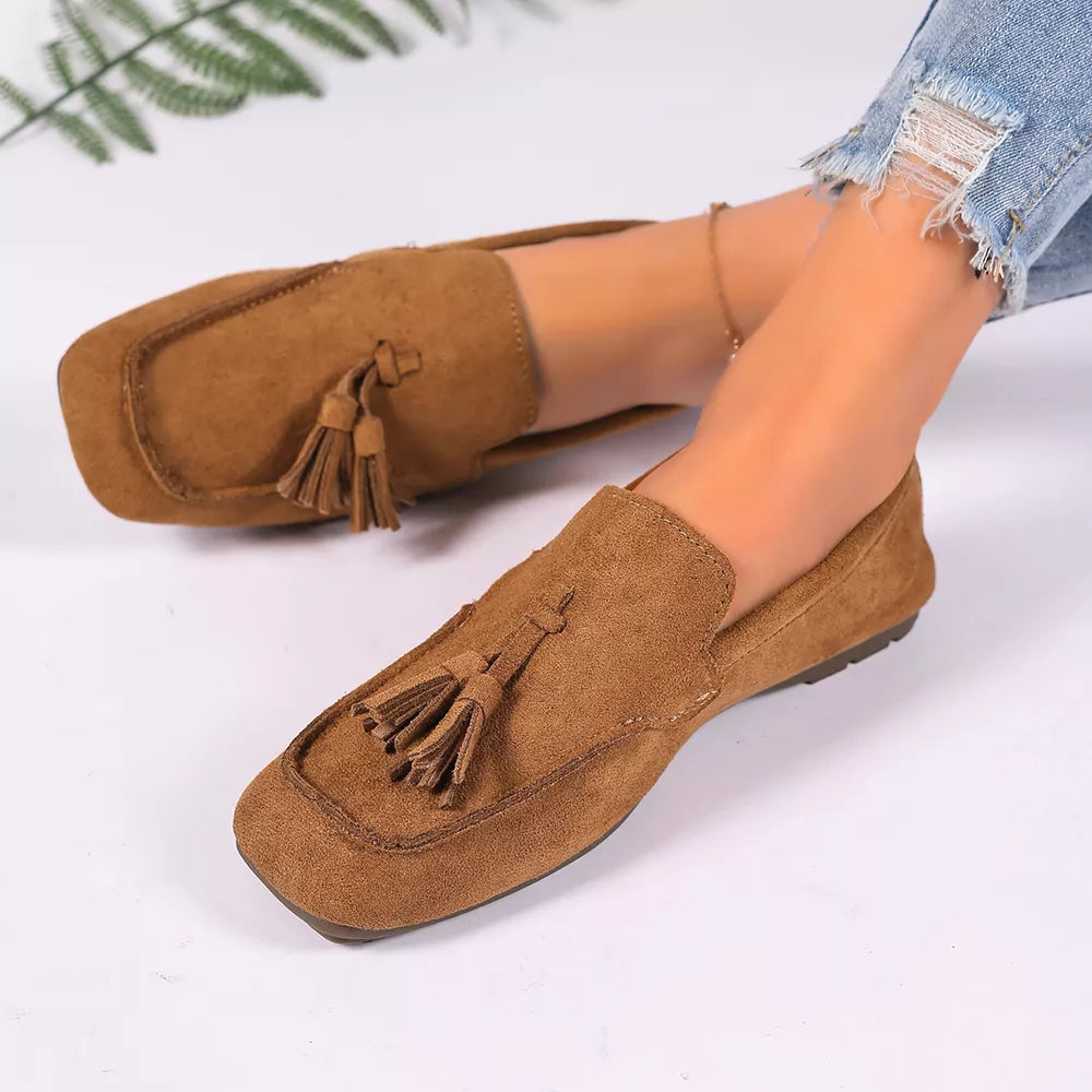 Brown suede slip-on loafers with double tassel detail.