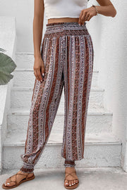 Bohemian multicolor striped smocked waistline trousers with cinched ankles.