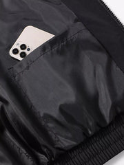 Black bomber jacket with a phone in the chest pocket and elasticized hem.