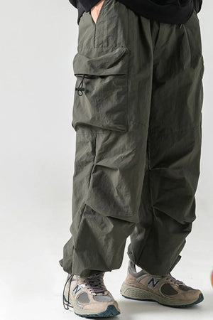 Oversized utility cargo trousers in dark gray with multiple pockets and drawstring details.
