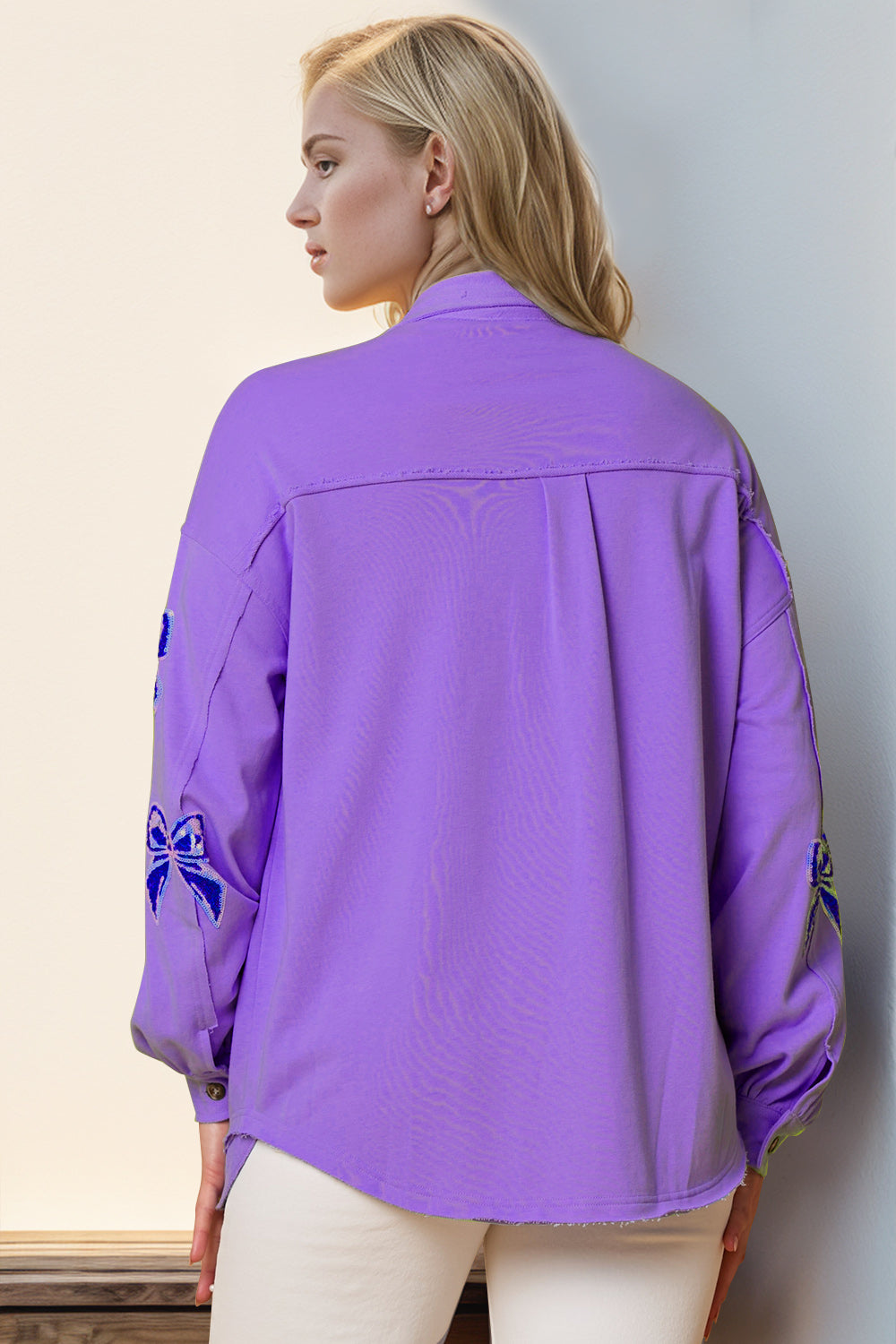 Purple oversized shacket with embroidered blue bow details on the sleeves.
