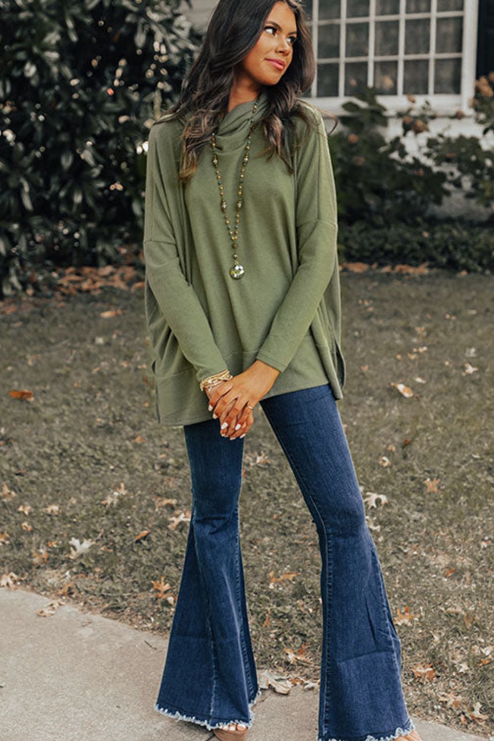Army green tunic with cowl neckline and long sleeves, styled with flare jeans.