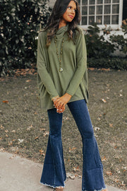 Army green tunic with cowl neckline and long sleeves, styled with flare jeans.