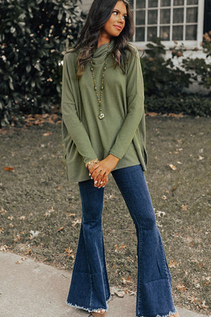 Army green tunic with cowl neckline and long sleeves, styled with flare jeans.