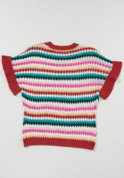 Textured knit sweater with diamond pattern and contrast trim in red.