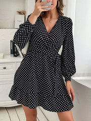 Black polka dot mini dress with V-neck, balloon sleeves, and ruffled hem.