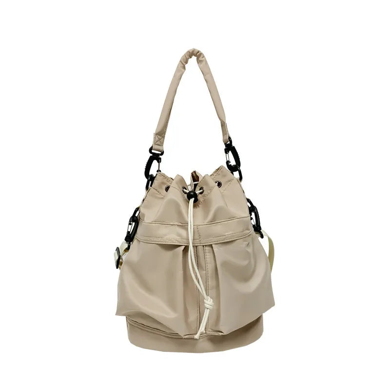 Beige nylon drawstring bucket bag with chain detail and top handle