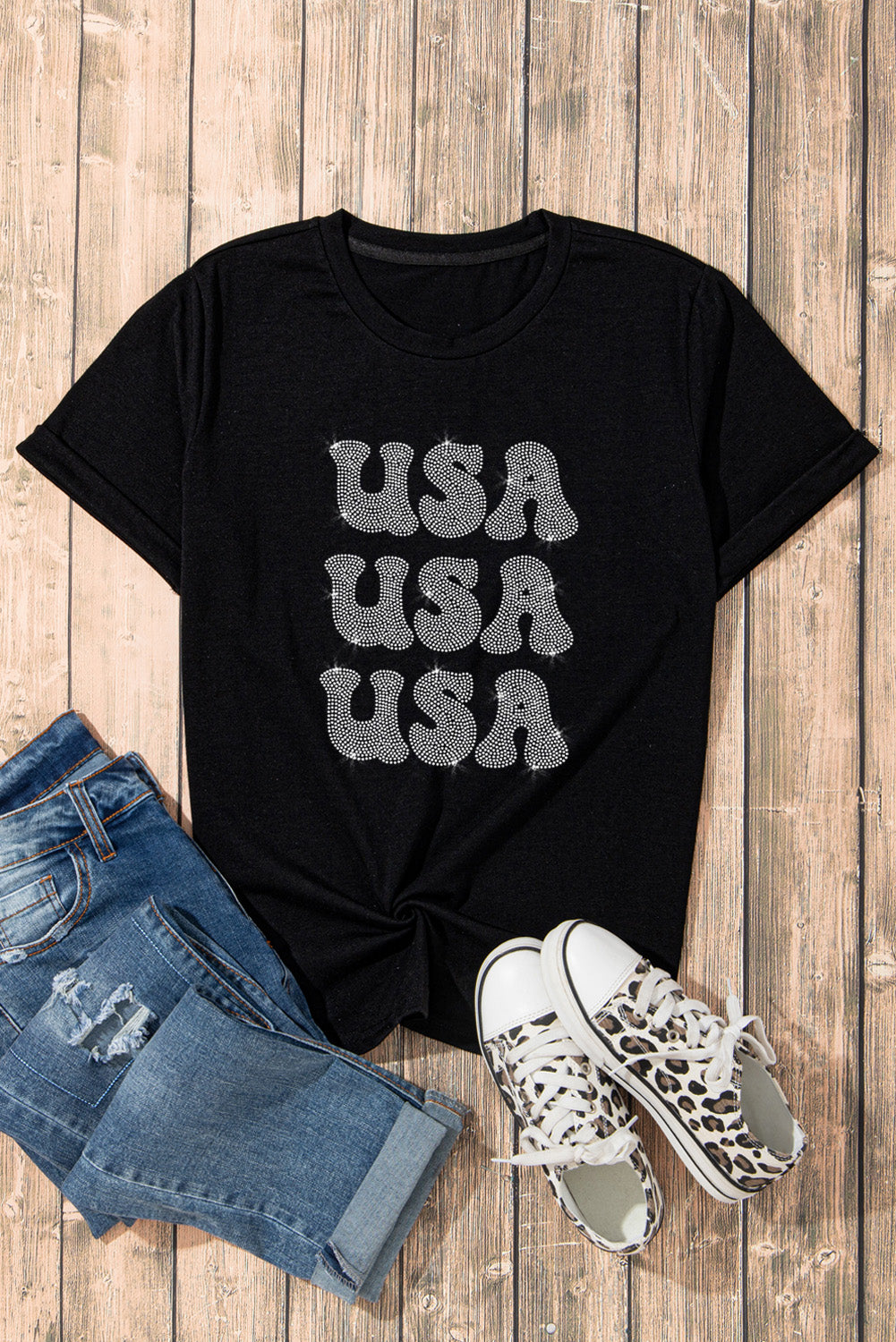 Black t-shirt with stacked rhinestone USA graphic and rolled sleeves.
