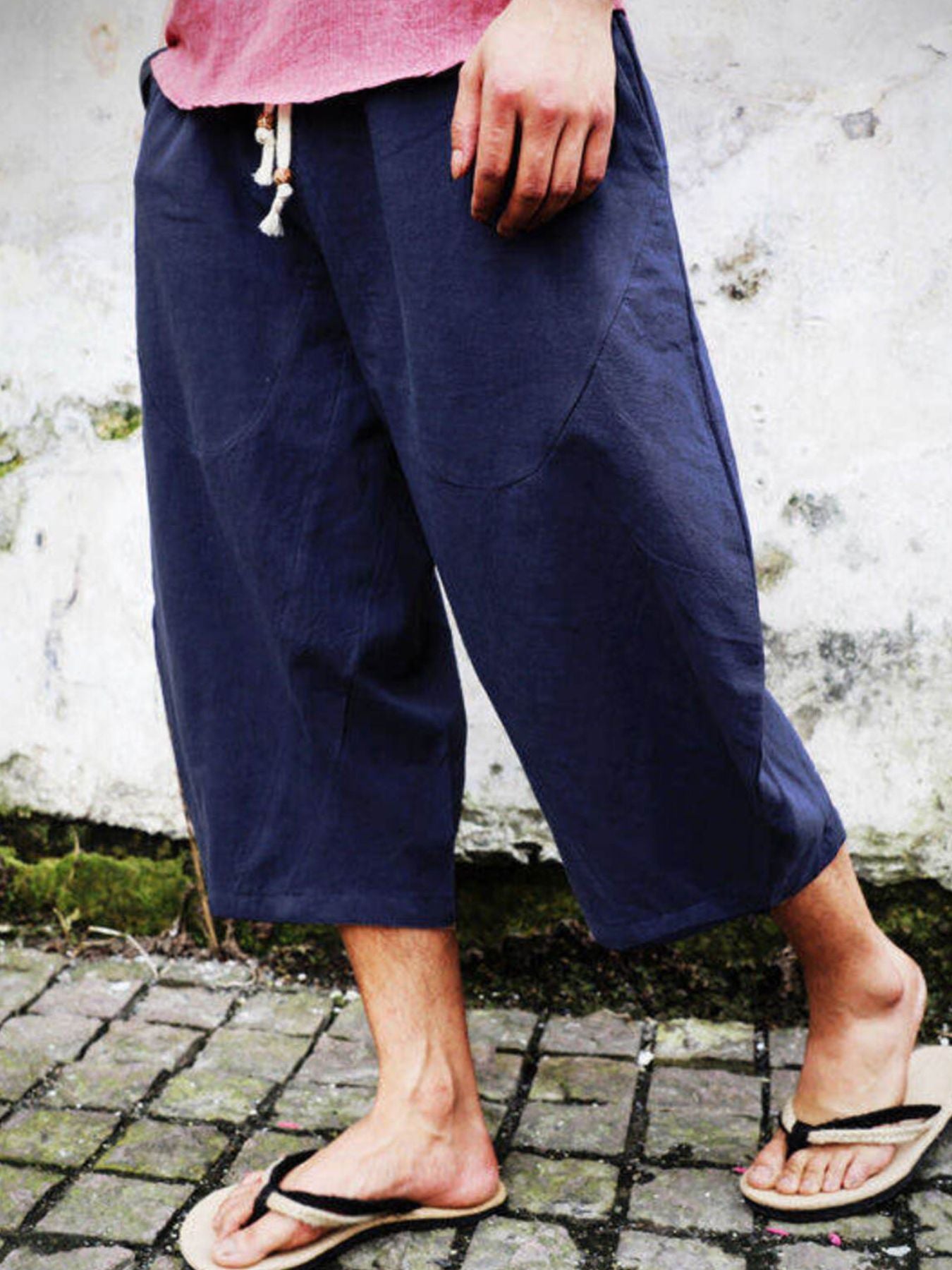 Navy blue relaxed fit cropped sweatpants with drawstring waist and pockets.