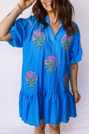 Blue embroidered floral dress with V-neck, short sleeves, and ruffle hem.