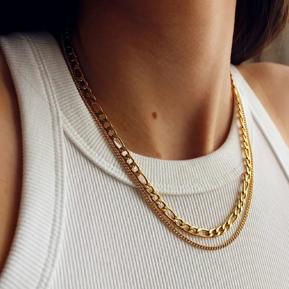 Dual-strand gold curb chain necklace layered over a white tank top.
